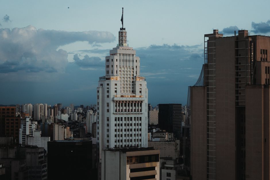 Economia São Paulo — A striking view of an iconic skyscraper in São Paulo's cityscape against a cloudy sky.